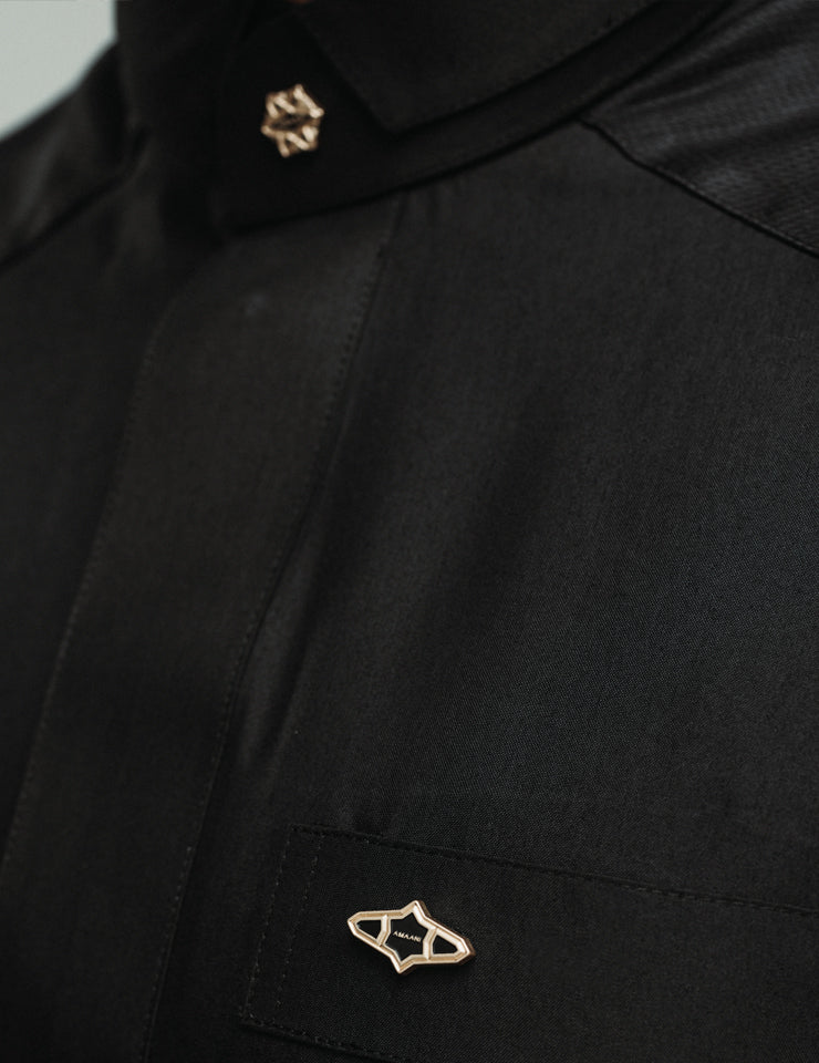Amaani Stark kids thobe in black with patterned shoulders and signature collar buttons